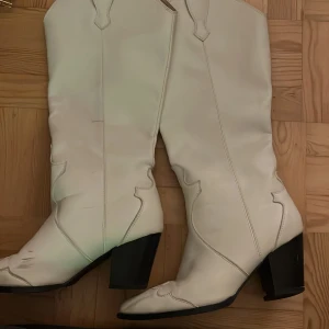 Vita cowboy boots med klack - Snygga vita cowboy boots med markerade sömmar. Köpta på Vinted men har bara använt en gång😇Storlek 37, klacken är lite sönder men går nog att laga rätt enkelt!