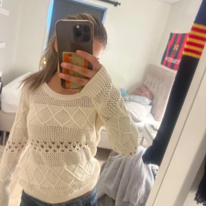 Beige stickad tröja med mönster - Säljer en beige stickad tröja med snygga hålmönster och diamantformade detaljer. Tröjan har rund halsringning och långa ärmar. Perfekt för lager-på-lager och ger en chill men ändå stilren vibe.