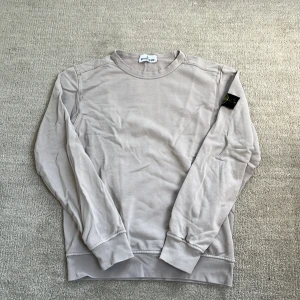 Stone Island Sweatshirt  - Tja! Säljer nu denna feta Stone Island sweatshirten! Den är i riktigt bra skick som man ser på bilderna. Den är i storlek 12 år/ 156, men jag skulle säga att den passar 165. Den är självklart äkta. Nypris: 3999 kr❌‼️Mitt pris: 1499kr ✅ Skriv vid minsta fundering eller fråga och pris kan diskuteras!🤝