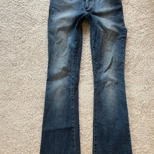 Blå bootcut jeans från Chick - Snygga blå bootcut jeans från Chick. Har många unika och snygga broderingar med turkosa knappar. Helt normal i storlek! Priset kan diskuteras! 🩷Innerbenslängd-77cm midjemått-35cm