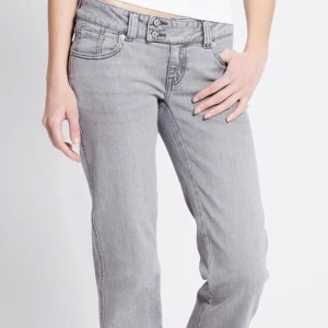 Grå jeans med broderade bakfickor - Snygga grå jeans med raka ben och broderade detaljer på bakfickorna. Jeansen har låg midja och klassisk femficksdesign. Tillverkade i mjukt denimtyg som ger en avslappnad och cool look. Har använt dessa byxor en gång då jag inte tycker att dem passar mig så bra. Jag är 170cm och längden på dessa jeans är bra längd.