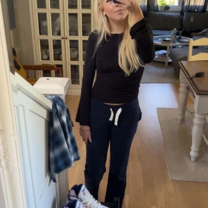 Svart långärmad topp med utsvängda ärmar - Säljer en svart långärmad topp med tight passform och utsvängda ärmar. Enkel och stilren design med rund halsringning. Perfekt att matcha med jeans eller kjol för en clean look.