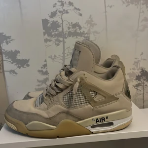 Nike Air Jordan 4 Off-White Sail - Exklusiva Nike Air Jordan 4 Off-White i färgen Sail. Beige och gråa toner med meshpaneler, tydliga Off-White-detaljer som 'AIR'-text på sulan och genomskinliga plastdetaljer. Skorna har snörning, platt sula och ikonisk Jordan-silhuett. Perfekta för dig som gillar streetwear.pris ej hugget !