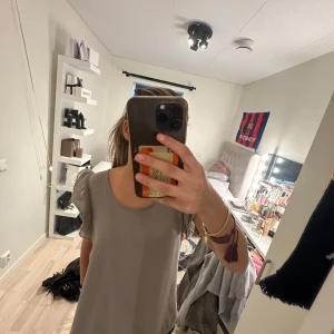 Grå blus med volangärmar - Säljer en stilren grå blus med breda volangärmar och rund halsringning. Blusen är ärmlös med snygga plisserade detaljer på axlarna som ger en cool touch. Perfekt att styla med jeans eller kjol för en trendig look.