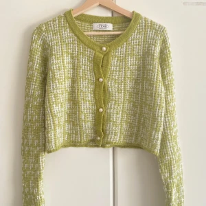 Grön kofta från Cider med pärlknappar - Superfin grön och vit kofta från Cider med rutigt mönster och croppad passform. Koftan har långa ärmar, rund halsringning och snygga pärlknappar framtill. Perfekt att slänga över en topp för en trendig look.