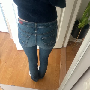 Blå bootcut jeans med låg midja - Säljer ett par klassiska blå jeans med låg midja och bootcut. Jeansen har snygga detaljer på bakfickorna. De är i stretchigt jeanstyg som sitter tajt och passar perfekt! Köpta på sellpy, osäker på strl men passar på mig som brukar ha ca 34 i jeans och har innebenslängd på 80 cm.