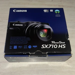 PowerShot SX710 HS - Canon PowerShot SX710 HS kompaktkamera med 20,3 MP, 30x optisk zoom, WiFi och Full HD-video. Levereras med originalkartong, laddare och kablar. Kameran är i gott skick med skärmen har fortfarande plast på sig, har aldrig dragit av den. Denna kamera är perfekt för resor och vardagsfotografering.