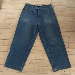 Polar Big Boy wide jeans blå denim - Säljer ett par Polar Big Boy jeans i klassisk blå denim med bred passform och råa, slitna benslut. Jeansen har hög midja, fem fickor och tydlig blå etikett bak. Perfekta för dig som gillar loose och baggy stil.