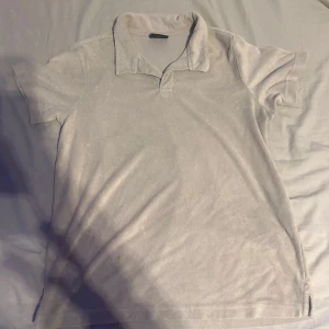 Beige frotté t-shirt  - Säljer en beige t-shirt i mjuk frotté med klassisk krage och korta ärmar. Perfekt för dig som gillar en chill och avslappnad stil. Enkel design utan mönster, passar till det mesta och är superbekväm.