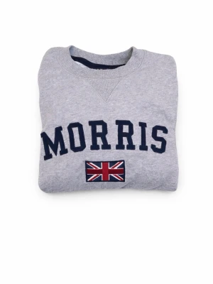 Grå sweatshirt från Morris - Säljer en stilren grå sweatshirt från Morris med texten 'Morris' och en brittisk flagga på framsidan. Tröjan är storlek M, skick 8/10. Tveka inte att skriva.    Nypris 1199kr mitt pris: 200kr