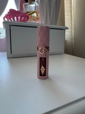 Charlotte Tilbury Pillow Talk Big Lip Plumpgasm - Säljer en Pillow Talk Big Lip Plumpgasm från Charlotte Tilbury. Läppglanset kommer i en lyxig ljusrosa tub med quiltad struktur och detaljer i roséguld. Färgen är en djup rosa-nude som ger fylliga och glansiga läppar. Perfekt för dig som vill ha plumpade läppar med snygg glans.
