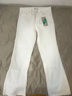 Vita raka jeans från Gina Tricot - Säljer ett par vita jeans från Gina Tricot med rak passform och råa, avklippta benslut. Klassisk femficksmodell med hög midja och bälteshällor. Jeansen är i ett tjockare bomullstyg och har en enkel, clean look.