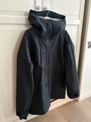 Skidjacka  - Skidjacka unisex modell från EQPE, storlek L I svart. Ingen fordring utan mer skaljacka så den passar alla väder! Den har snöskydd på insidan och recco reflektor inbyggd! Lite längre över rumpan och har massor av fickor. Använd några fåtal gånger så väldigt fint skick😊