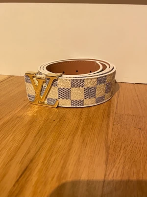 Trendigt bälte 115 cm  - Säljer ett ljust bälte med rutigt mönster och guldigt spänne 115cm lång  med väldigt fin kvalité och är helt ny. För följdfrågor så kan du bara skriva.