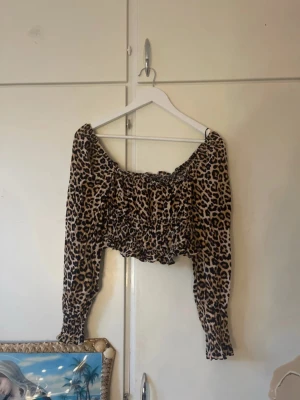 Leopardmönstrad croppad topp H&M - Säljer en croppad topp från H&M med leopardmönster. Toppen har långa ärmar med resår vid ärmslut. Volanger vid kanterna. Aldrig använd, inte min stil. 