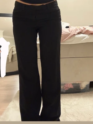 Svarta kostymbyxor med wide fit - Snygga svarta kostymbyxor med klassisk wide fit och midwaist. Byxorna har en stilren look med raka ben och diskreta fickor fram och bak. Perfekta för dig som gillar en enkel och clean stil. Materialet känns mjukt och följsamt mot kroppen.💕