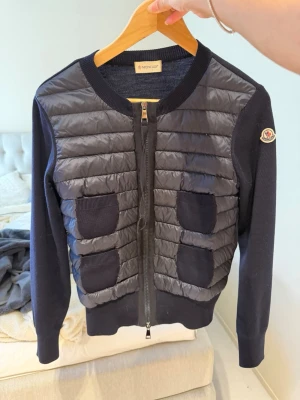 Moncler cardigan marinblå - Säljer den populära moncler cardiganen i marinblå! Storlek S och är i väldigt fint skick! Nypris är 7 000 kr och köptes under våren 2022. 