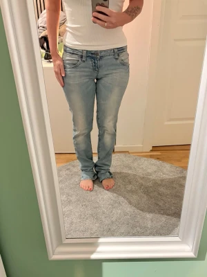 Ljusblå jeans från Fishbone - Säljer ett par Fishbone jeans i ljusblå.. Modellen har raka ben, fem fickor och knappgylf. Jeansen har en normal passform och låg midja. Jag är 162 och dom är för långa för mig. Tror det kan va 31 i längd