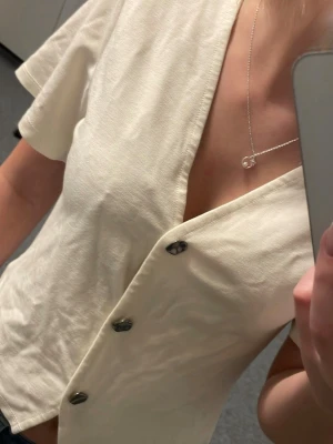 Vit tröja med knappar  - En kortärmad vit topp ifrån lager157 i storlek S. På framsidan har den silvriga knappar och är v-ringad. Inte använt mycket. 