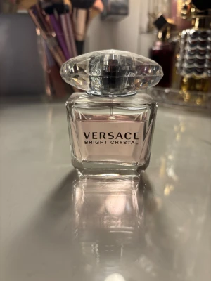 Versace Bright Crystal parfym - Versace Bright Crystal – en ikonisk parfym med lyxig känsla och stilren design. Perfekt för dig som vill sticka ut och addera en touch av elegans till din vardag. Snygg flaska med rosa innehåll, passar perfekt på sminkbordet. Parfymen e använd som man ser på bilderna man ser även hur mycket det är kvar på dem. Köpt på kicks men säljer då jag inte tycker om doften på mig, har tyvärr inte kvar låda eller kvitto. 30ml