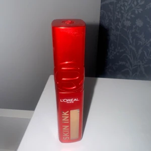 L'Oréal Skin Ink foundation - Foundation från L'Oréal Paris i serien Skin Ink. Kommer i en snygg röd förpackning med genomskinligt fönster som visar den ljusa nyansen. Perfekt för att få en jämn och fräsch bas. Smidig och modern design.