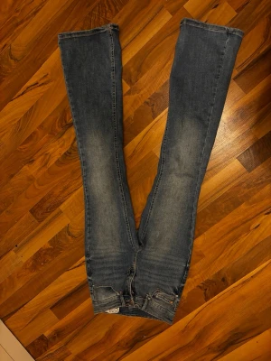 Blå jeans  - Säljer ett par mellanblå bootcut jeans från Vero Moda. På baksidan av ena benet längst ned är en liten detalj med ett bi jag broderar själv.🥰🥰