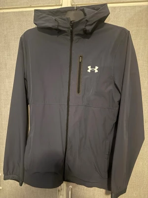 Mörkblå vindjacka från Under Armour - Vindjacka från under armour väldigt bra skick bytt dragkedja för original var väldigt dålig kvalite strl M