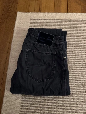 Jacob Cohen  - Säljer ett par grå/blåa byxor från Jacob Cohen med klassisk femficksdesign och raka ben. Bra skick i storlek 32