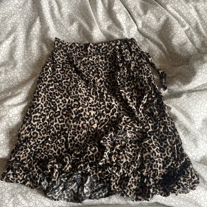 Leopardkjol - Snygg kortare omlottkjol från Lindex med leopardmönster. Kjolen har volang nedtill och en knytdetalj på sidan. Den är i barnstorlek men passar mig som vanligtvis är xs/s💗
