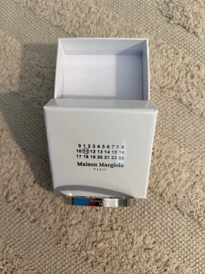 Maison margiela armband - Maison margiela armband i helt nytt skick. Snyggt glansigt armband med inristad text och detaljer som verkligen lyfter outfiten. Vid frågor eller pris kom DM!