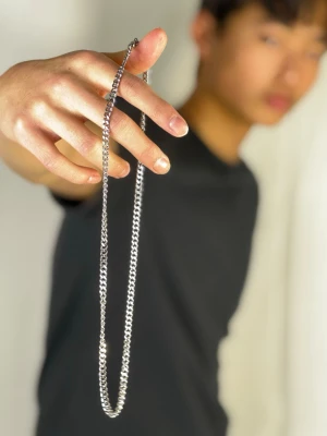 Kedjehalsband i silverfärgat stål - Stilrent halsband med klassisk kedjelänk i silverfärgat rostfritt stål. Passar perfekt för att ge din outfit en clean och modern touch. Halsbandet har en enkel och tidlös design som funkar till många olika stilar. 55cm.