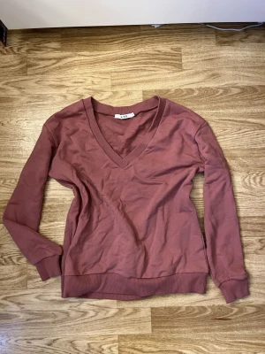 Rosa v-ringad tröja från NA-KD - Enkel och snygg gammelrosa tröja från NA-KD i storlek XS. Tröjan har djup v-ringad hals, långa ärmar och ribbade muddar vid ärmslut och nederkant. Perfekt till många olika tillfällen!