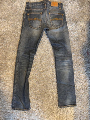 Nudie jeans 29/32 grim tim  - Tjena, säljer nu mina nudie jeans grim tim i storleken 29/32. Sjukt snygga och passformen är skön och färgen desamma! Släng iväg en fråga eller förslag så kan vi prata!🙌🏽(har en liten lagad bit men syns ej vid användning, samt en liten fläck som dock går bort i tvätten!)