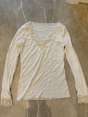Vit intimissimi tröja - Intimissimi tröja med spets runt v-ringningen och rund handlederna. Använd fåtal gånger.