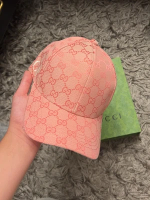 Rosa keps med-mönster - Exklusiv rosa keps från med ikoniskt monogram i ton-i-ton. Kepsen är tillverkad i bomull och har en klassisk böjd skärm. Snygg detalj med liten guldfärgad logga på sidan. Perfekt accessoar för att lyfta din outfit med lyxig känsla.