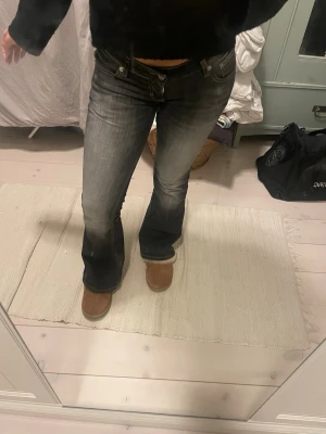Bootcut jeans i mörkgrå tvätt - Trendiga bootcut-jeans i Y2K-stil med låg midja. Modellen sitter tight upptill och är snyggt utsvängd nertill, vilket ger en smickrande passform.  Mörk/grå tvätt med lätt vintagekänsla som är enkel att styla till både vardag och mer uppklädda outfits.  Jeansen är endast använda cirka 2 gånger och i mycket fint skick. Inga slitningar eller defekter.  Helt rätt modell enligt dagens trender och svåra att hitta i den här passformen. Säljs då de inte kommer till användning. 