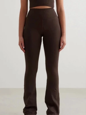 Bruna ribbade bootcut leggings - Säljer ett par bruna leggings med ribbad struktur och bootcut passform. De är högmidjade och har en tight men bekväm siluett som sitter snyggt över höfterna och låren. Perfekta att styla med en crop top eller oversized hoodie. Bara testade 