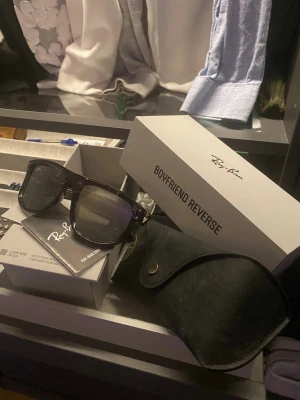 Ray-Ban Boyfriend Reverse solglasögon - Säljer ett par Ray-Ban Boyfriend Reverse solglasögon i modellen RBR0501S. Bågarna är transparent mörkgrå med spegelglas i silver och grå ton. Medföljer original Ray-Ban fodral och box. Snygg, modern och tidlös design som passar till allt.
