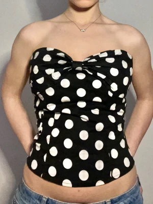 Topp med polka dots  - Axelbandslös top med polka dots. Den knäpps med en dragkedja i ryggen. Den har inga tecken på användning, men är däremot köpt second hand så det är oklart vilket märke den kommer ifrån. Hör av dig om du har några frågor! 🤗
