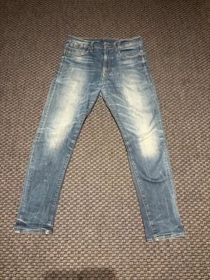 Blå RAW jeans - Riktigt feta jeans i bra kvalitet och bra passform. Snygg färg och har ett mjukt material som är mjukt mot benen. Riktigt snygg design på dessa byxor