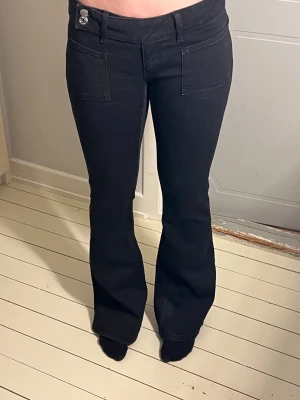 Svarta bootcut jeans med broderi - Snygga svarta jeans med bootcut passform och dekorativa broderade bakfickor. Jeansen har låg midja, framfickor och är tillverkade i ett mjukt jeansmaterial. Perfekta för dig som gillar en klassisk men ändå trendig look.💓