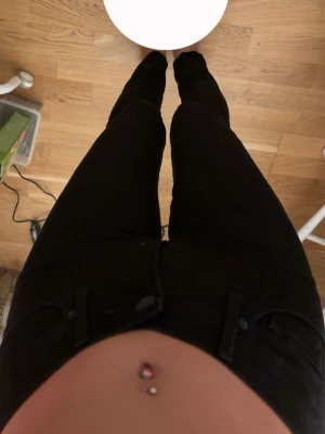 Levi's svarta skinny jeans 711 - Säljer ett par svarta Levi's jeans, modell 711, med hög midja och skinny fit. Jeansen har klassiska bakfickor med Levi's-logga, bälteshällor och dragkedjegylf. Materialet är stretchigt jeans-tyg som sitter tight och formar sig efter kroppen. Storlek 24. Köptes för 900kr