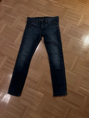 Replay anbass  - Säljer ett par schyssta Replay anbass jeans med slim fit passform. Jeansen har en skön tvätt och slitningar på fickor (del av designen) jeansen är i näst intill nyskick jeansen är storlek 33W 34L men passar mer 32W 32L