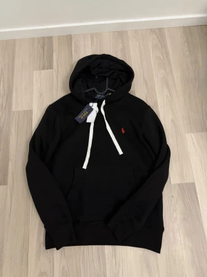 Ralph lauren hoodie  - Säljer en svart snygg Ralph lauren hoodie helt ny då den var för liten för mig den är slimfit i model och sitter mer som en stor S än M kontakt om du är  intresserad ställ frågor svarar snabbt 