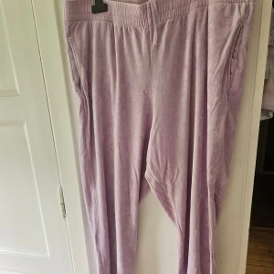 Ljuslila mjukisbyxor med snörning - Supermysiga ljuslila mjukisbyxor i storlek 2XL med mjukt tyg och skön passform. Byxorna har elastisk midja med snörning och praktiska sidofickor. Perfekta för chill dagar hemma eller när du vill vara extra bekväm.