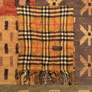 Vintage Burberry Halsduk  - -Riktigt bra skick. Nypris på dessa ligger på runt 5000kr, vilket gör detta till ett sjukt bra pris! Halsduken är gjord i Lamull, och är perfekt inför hösten och den kommande vintern. Anledningen till att det står ”Burberry’s” och inte ”Burberry” på lappen är eftersom halsduken är från några år tillbaka, innan de bytte namn! Om du har någon fråga är det bara att skriva till mig. /elgnce (5)
