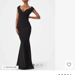 Svart långklänning med omlott - Elegant svart långklänning med omlott-design och v-ringad hals. Klänningen har en figurnära passform som framhäver silhuetten och är ärmlös för en stilren look. Perfekt för en skiva eller bal. (Har sytt en fin söm i midjan då den satt lite pösigt och rak)  