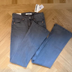 Grå flare jeans från Kappahl, stl 34 - Snygga grå flare jeans från Kappahl i storlek 34. Modellen har låg midja och stretch för extra komfort. Aldrig använda, prislapp kvar
