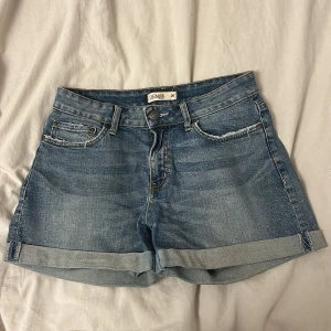 Denim shorts - Lindex  - Blåa shorts från Lindex där fickorna är slitna 