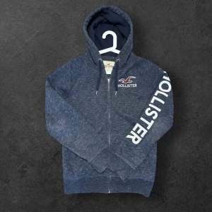 Hollister zip hoodie - Snygg vintage zip hoodie från hollister med riktigt stilrent tryck längs vänsterarmen, pris kan diskuteras 😁